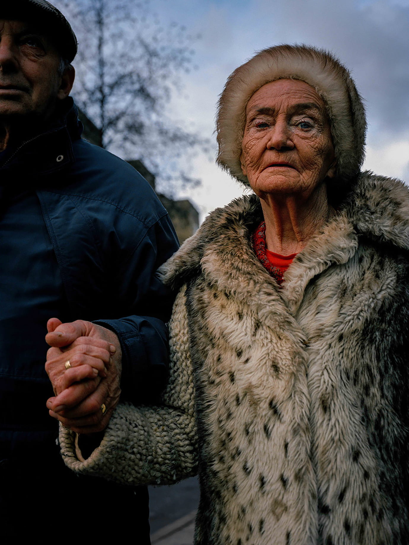 An elderly couple arm in arm.