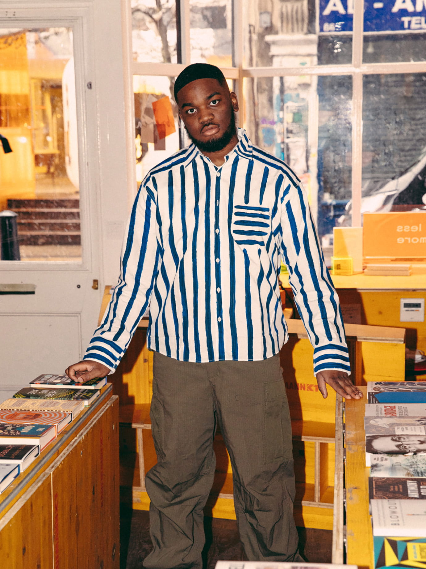 A man standing inbetween yellow bookshelves.