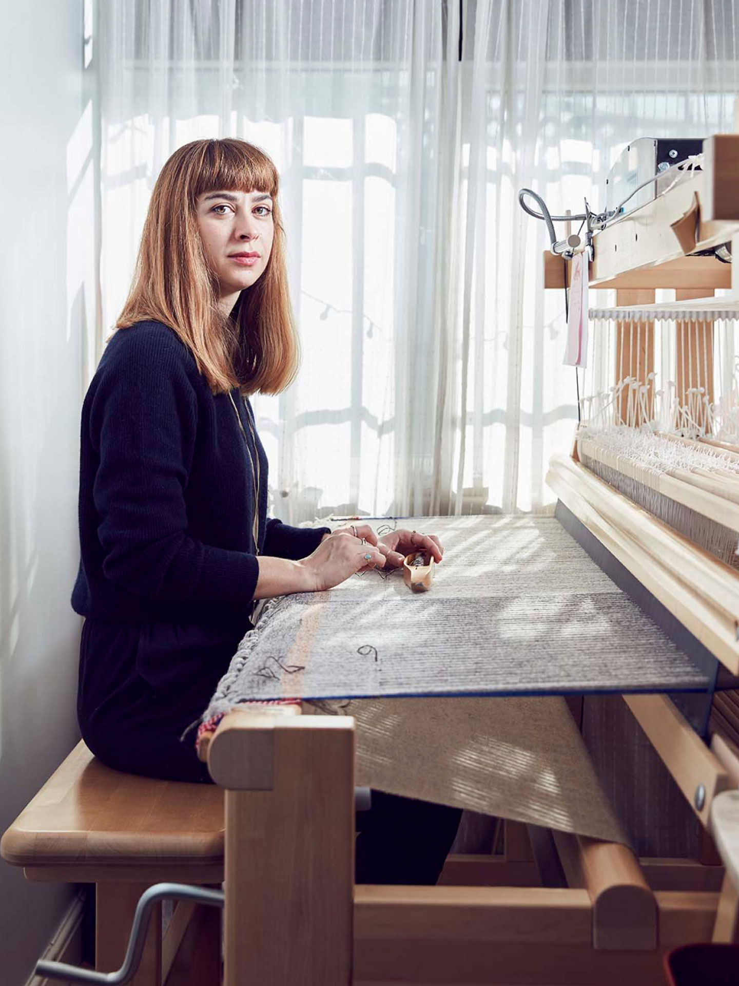 A woman weaving on a loom.