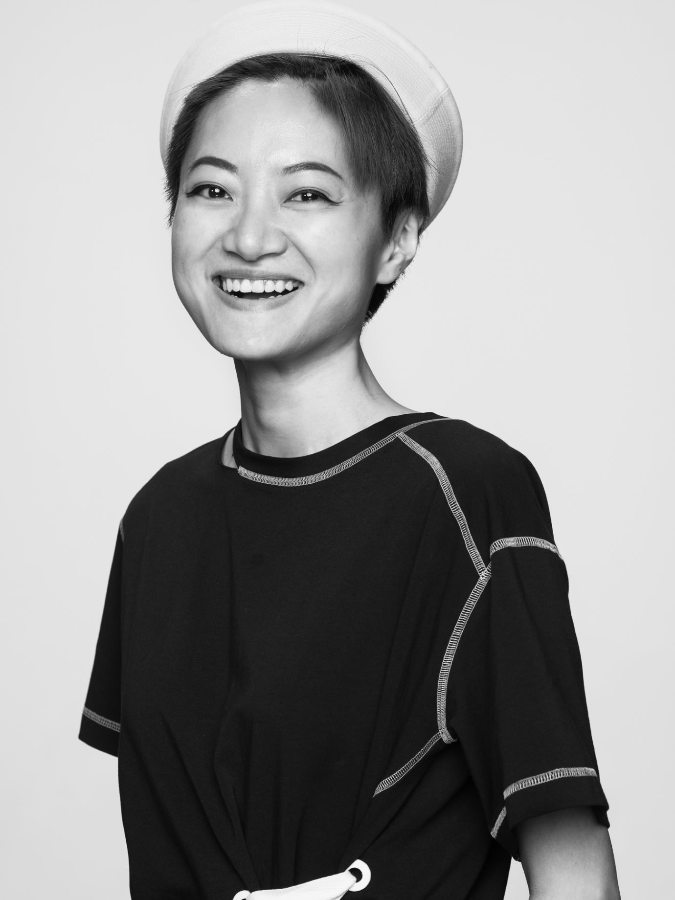 A woman in a sailor's hat laughing.