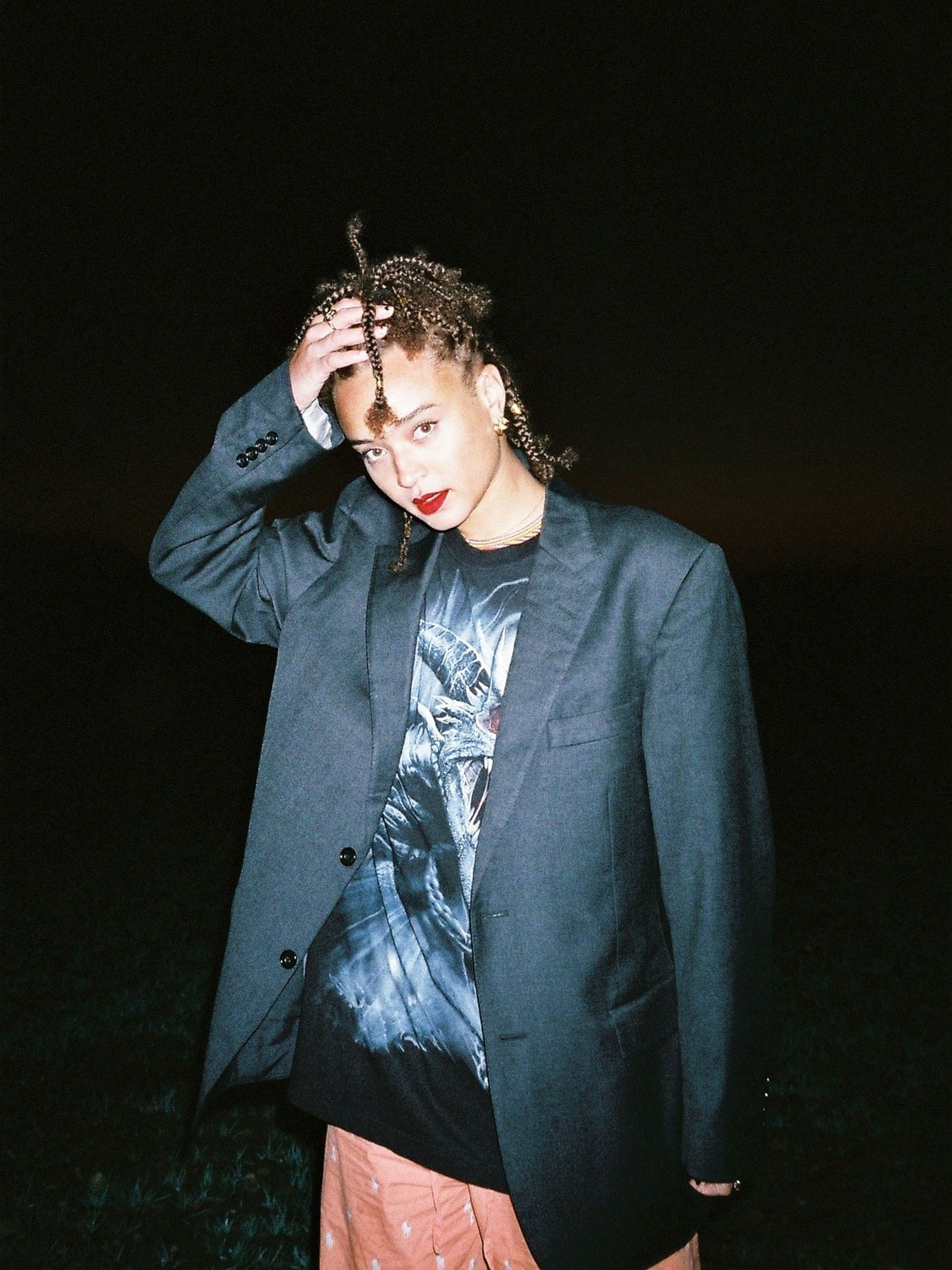 A woman wearing a suit jacket at night.