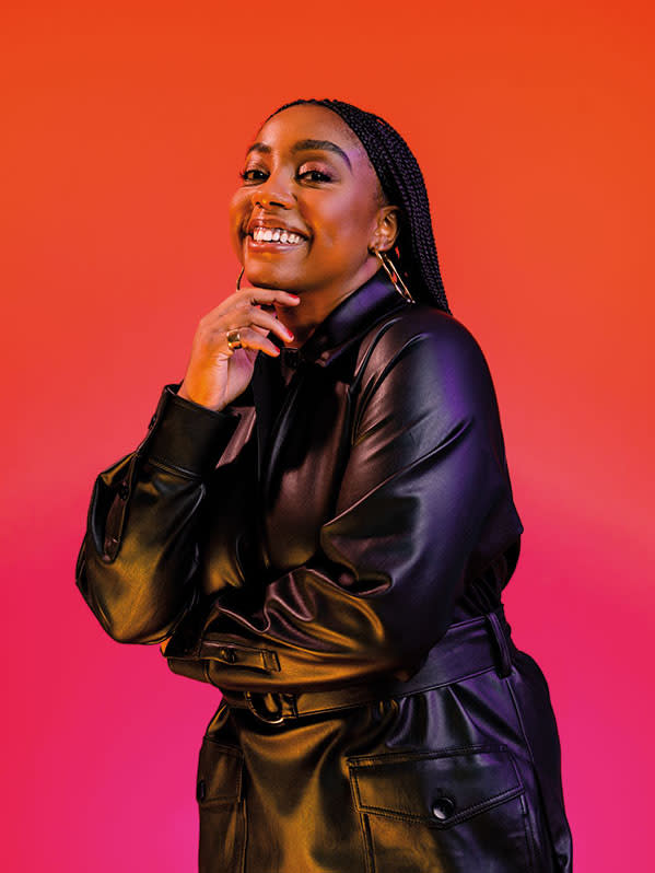 woman in black jacket against red background smiling