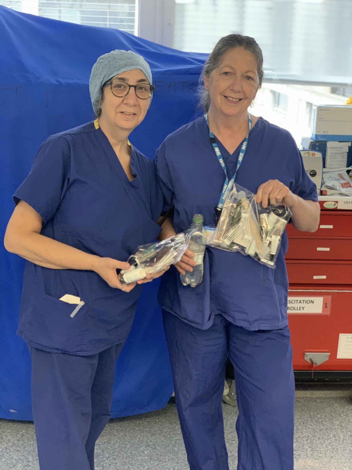 Two nurses in blue uniforms.
