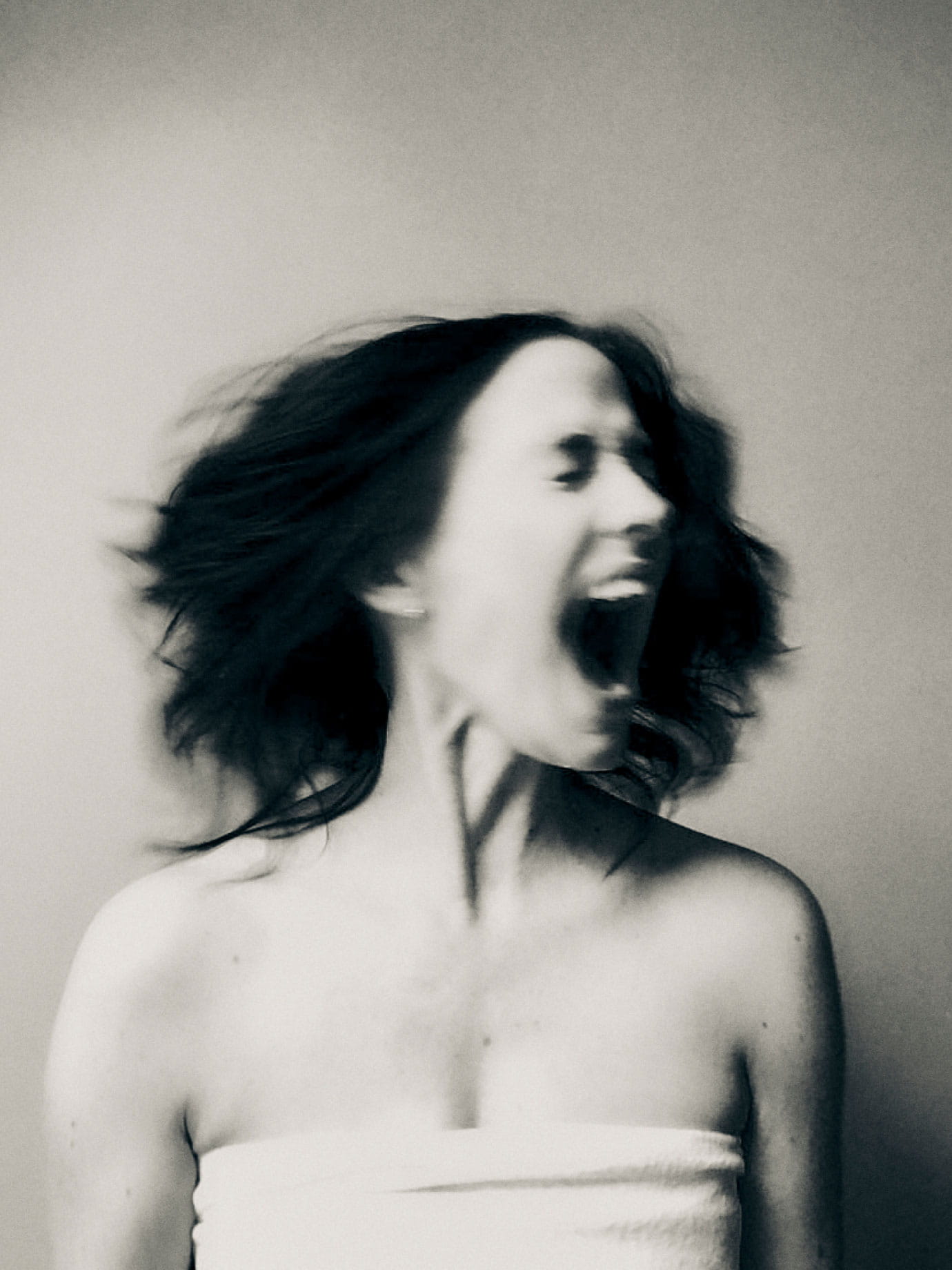 A woman screaming while shaking her head.