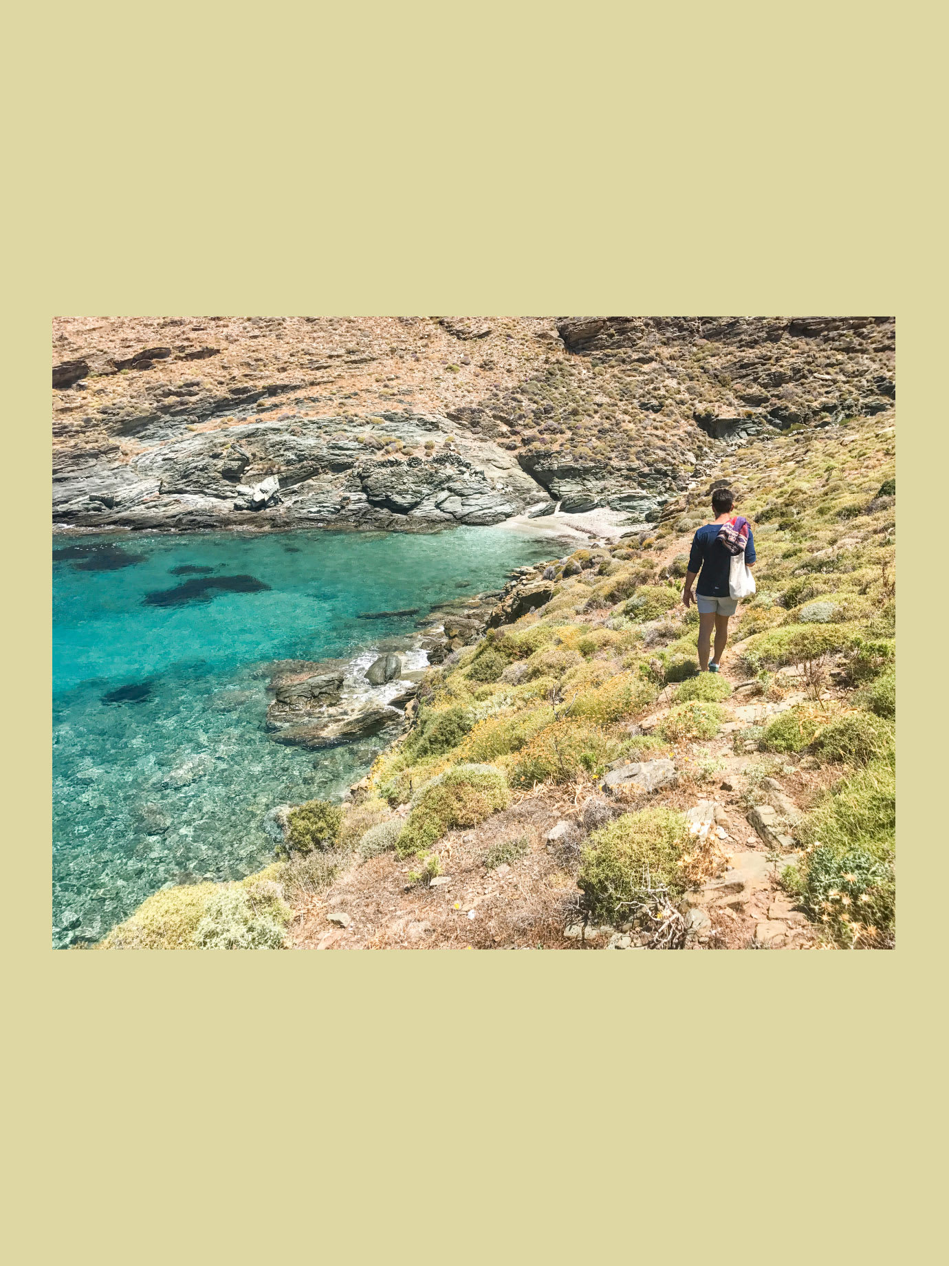 A man walking down a path towards the sea.