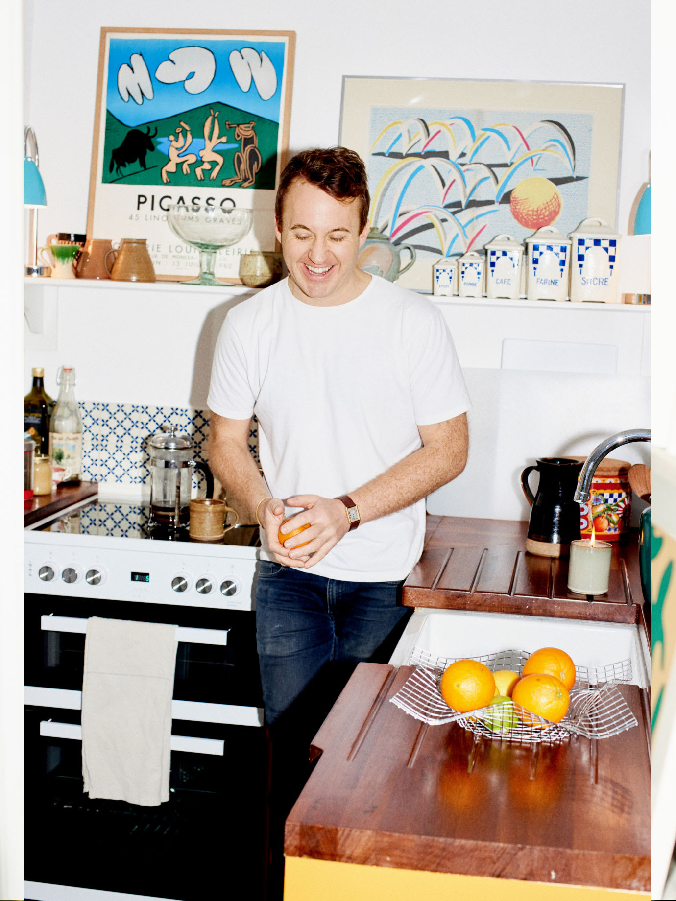 A man laughing in his kitchen.