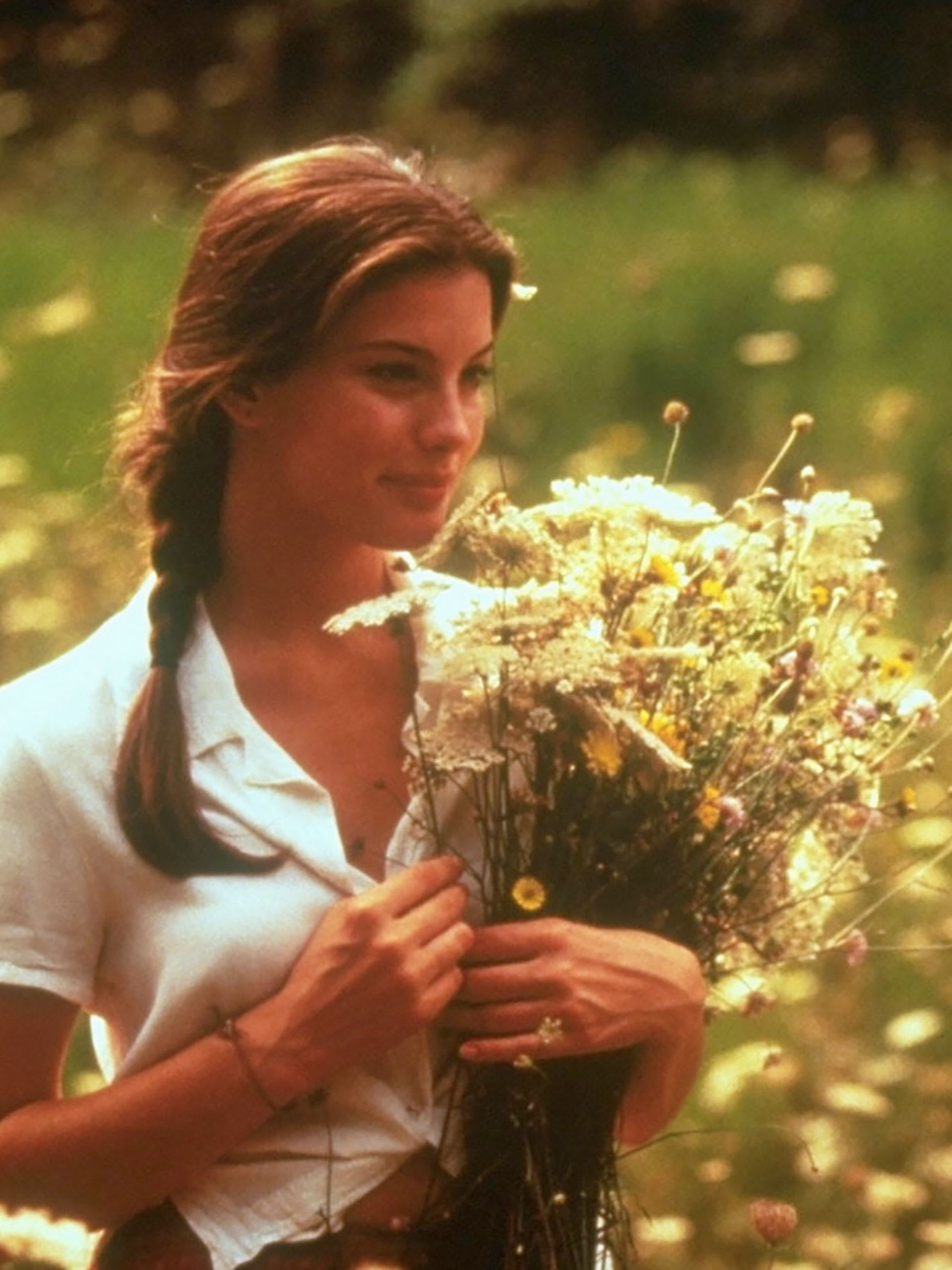 A woman holding a bunch of wild flowers.
