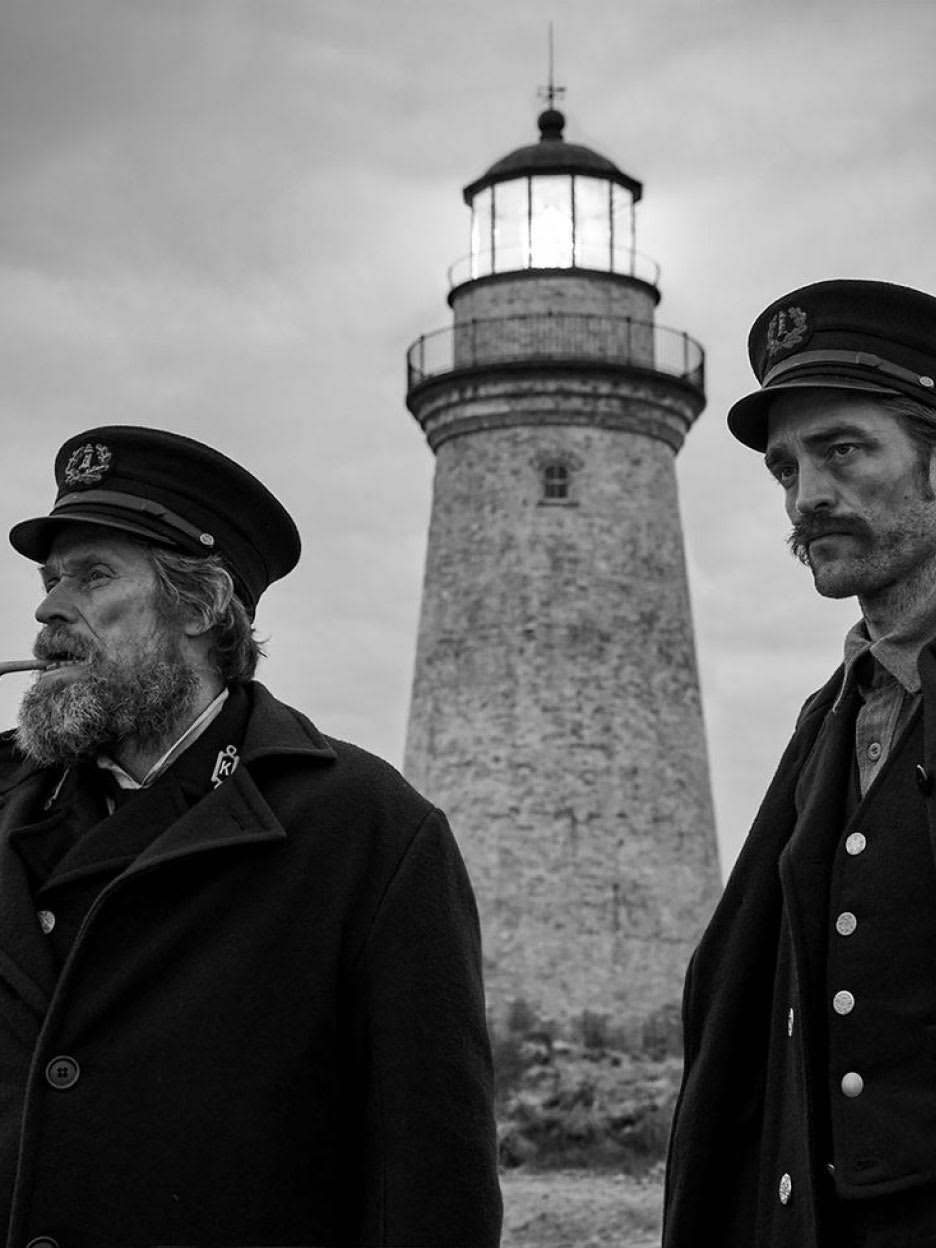 Two men standing outside a lighthouse.
