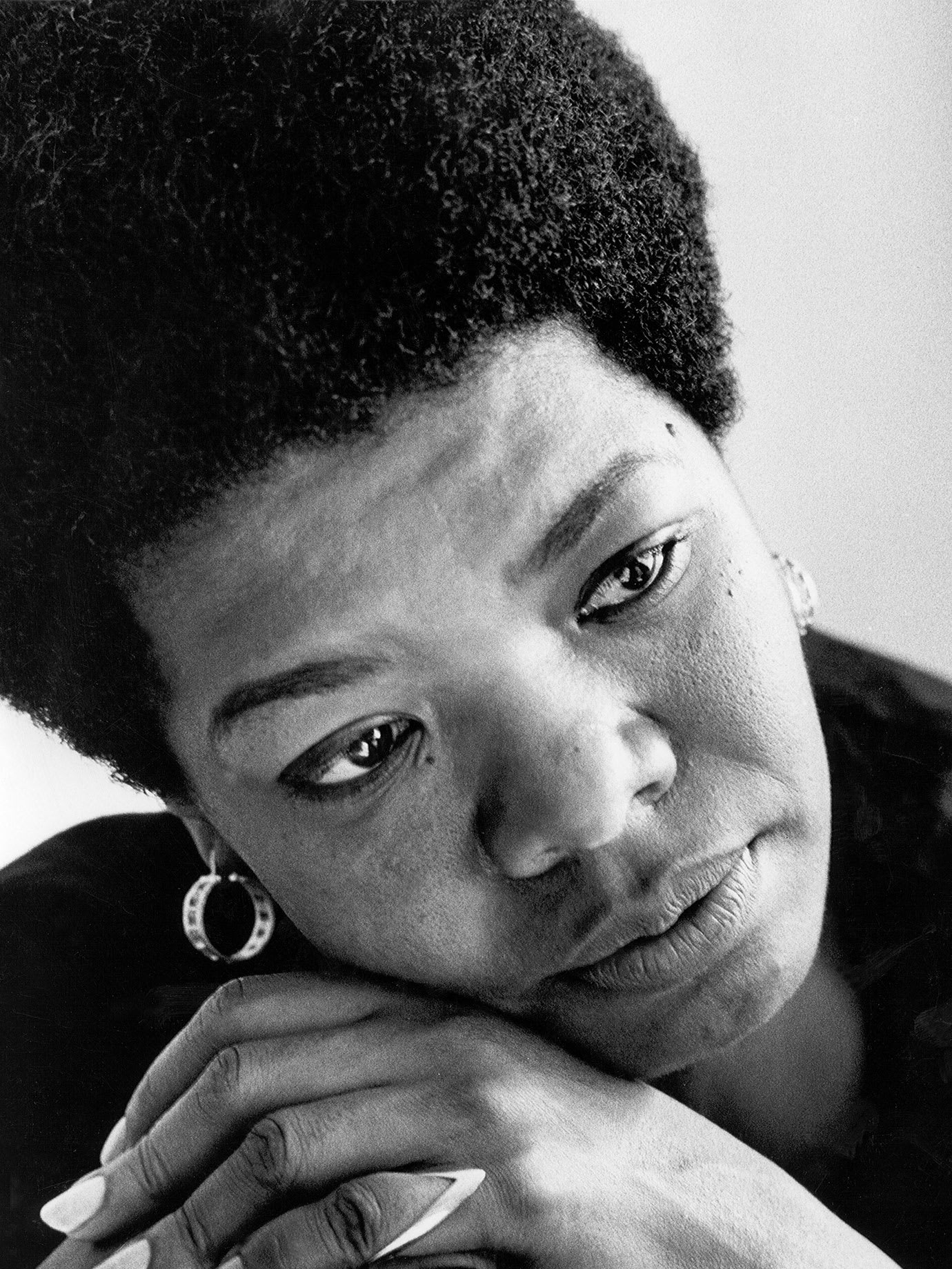 A woman frowning with her head resting on her hands.
