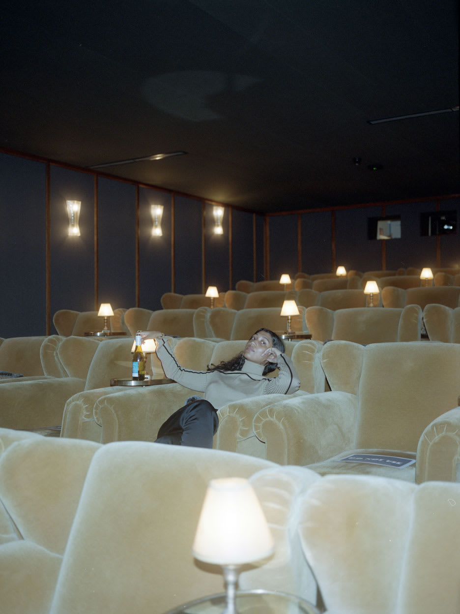 A woman sitting in a dark cinema.
