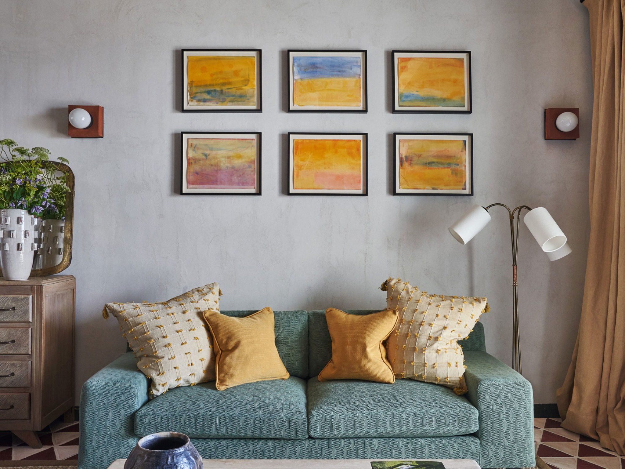 A blue sofa in a room decorated with paintings.