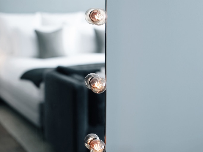A bed reflected in a mirror.