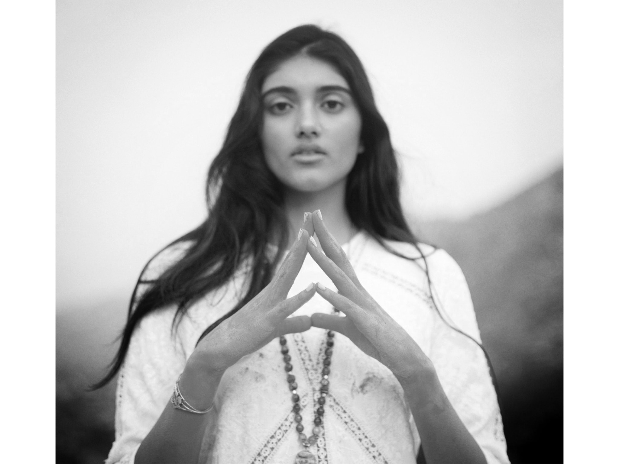 A woman with her fingers pressed together.