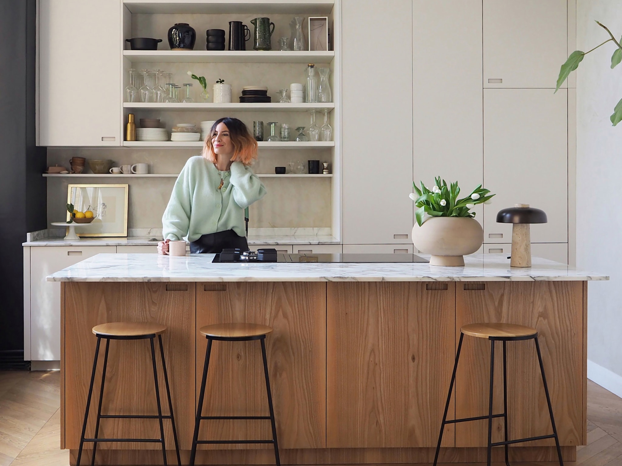 A woman standing behind a counter in a kitchen.
