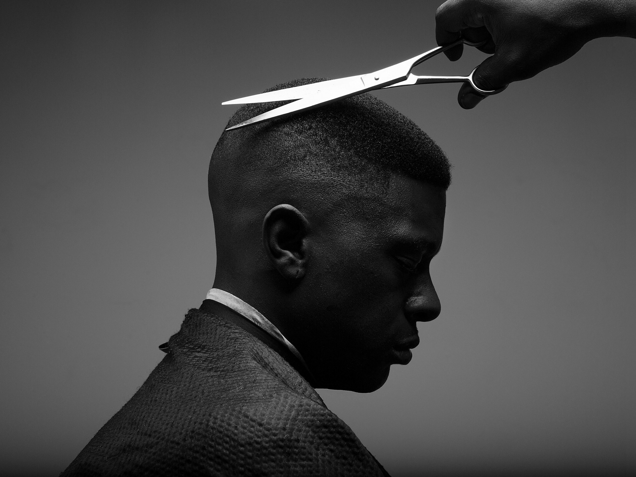 Scissors cutting a man's hair.