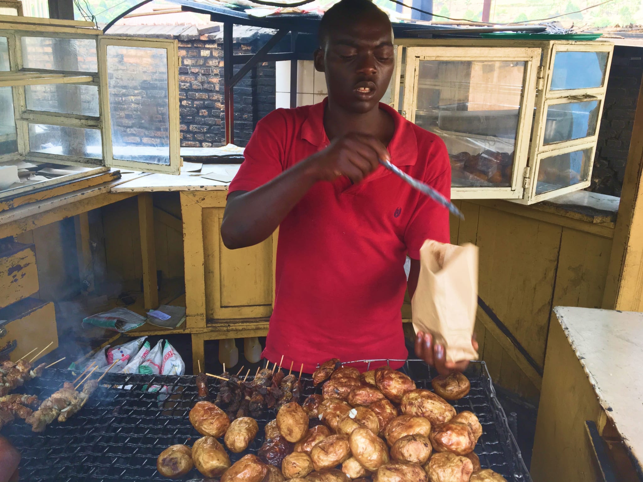A man cooking potatoes on a bbq.