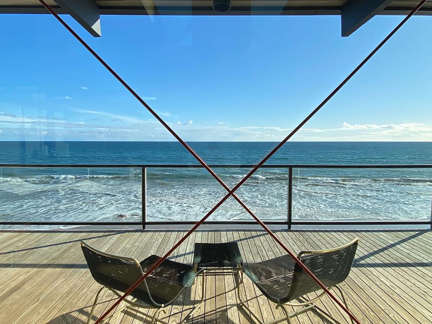 Two chairs on a terrace overlooking the sea.