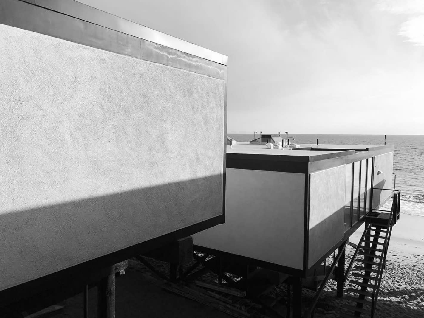 The exterior of a modernist house by the sea.