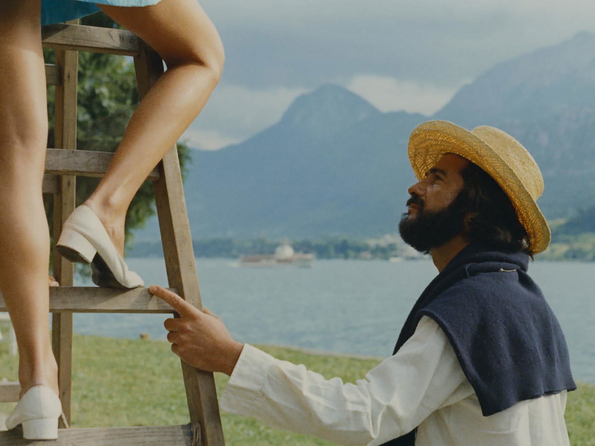 A man holding a ladder for a woman.