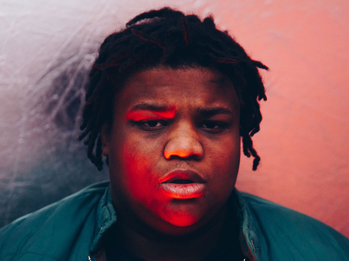 A man with pink light on his face.