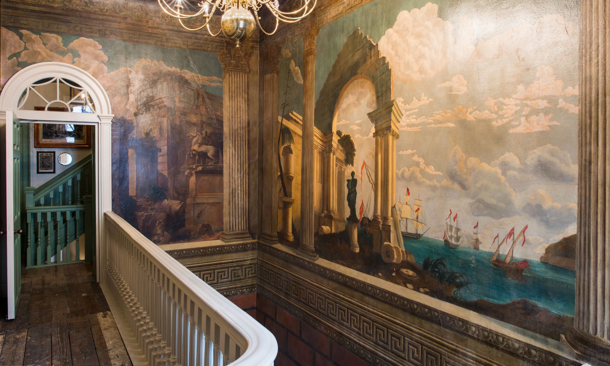 A stairwell with murals painted on the walls.