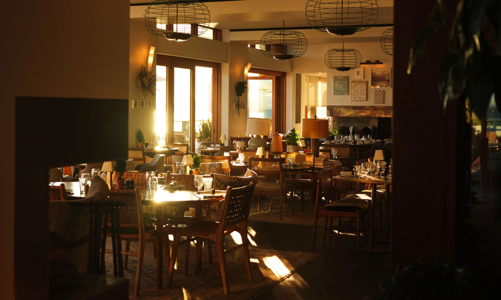 The sun cutting through an interior with tables and chairs.