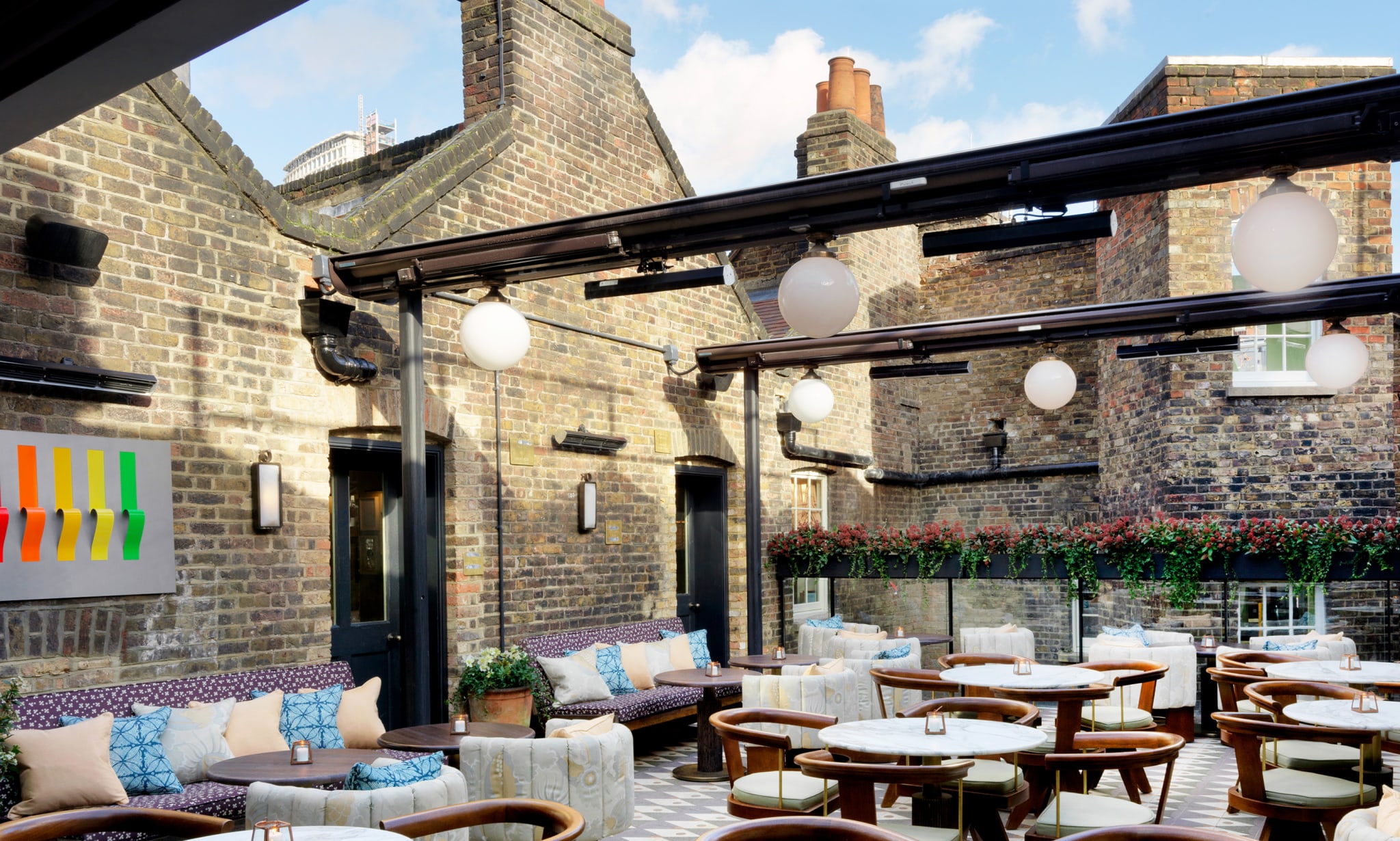 A roof terrace with many tables and chairs.