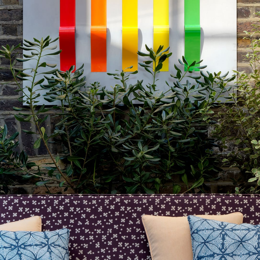 An outdoor seating area with a colourful artwork on the wall.