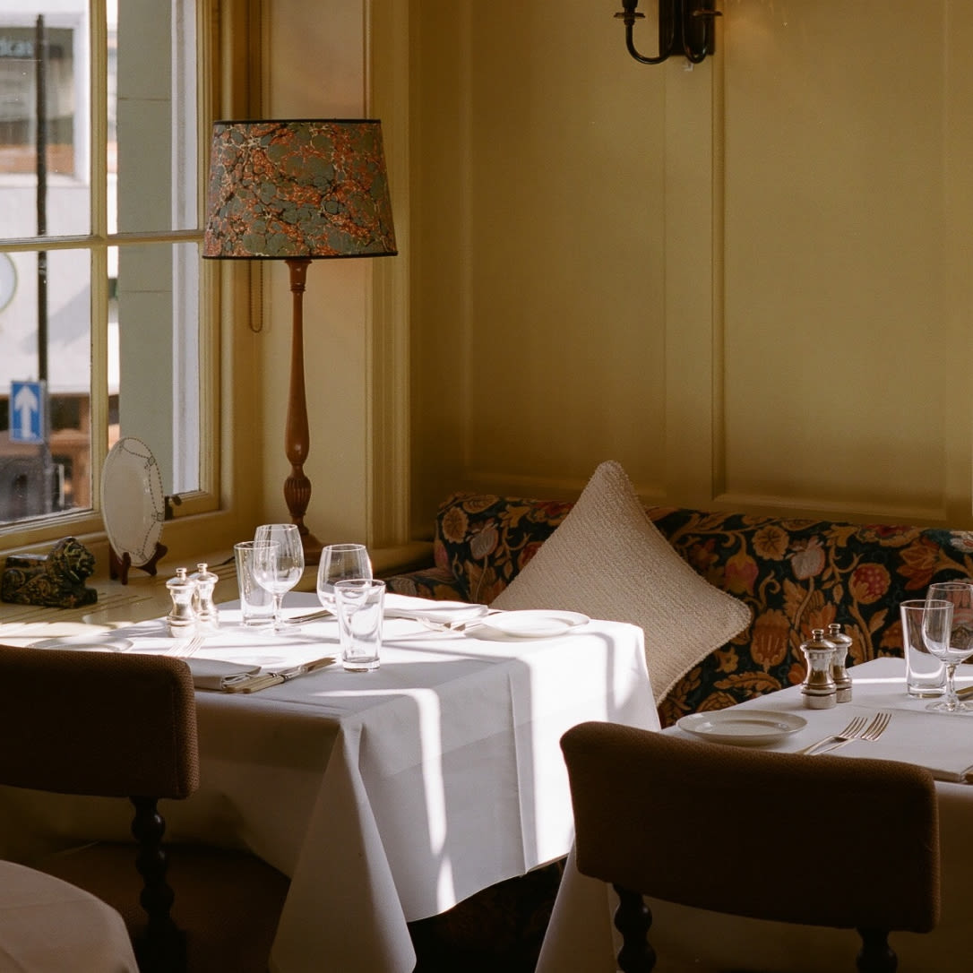 Two dining tables in a yellow room.
