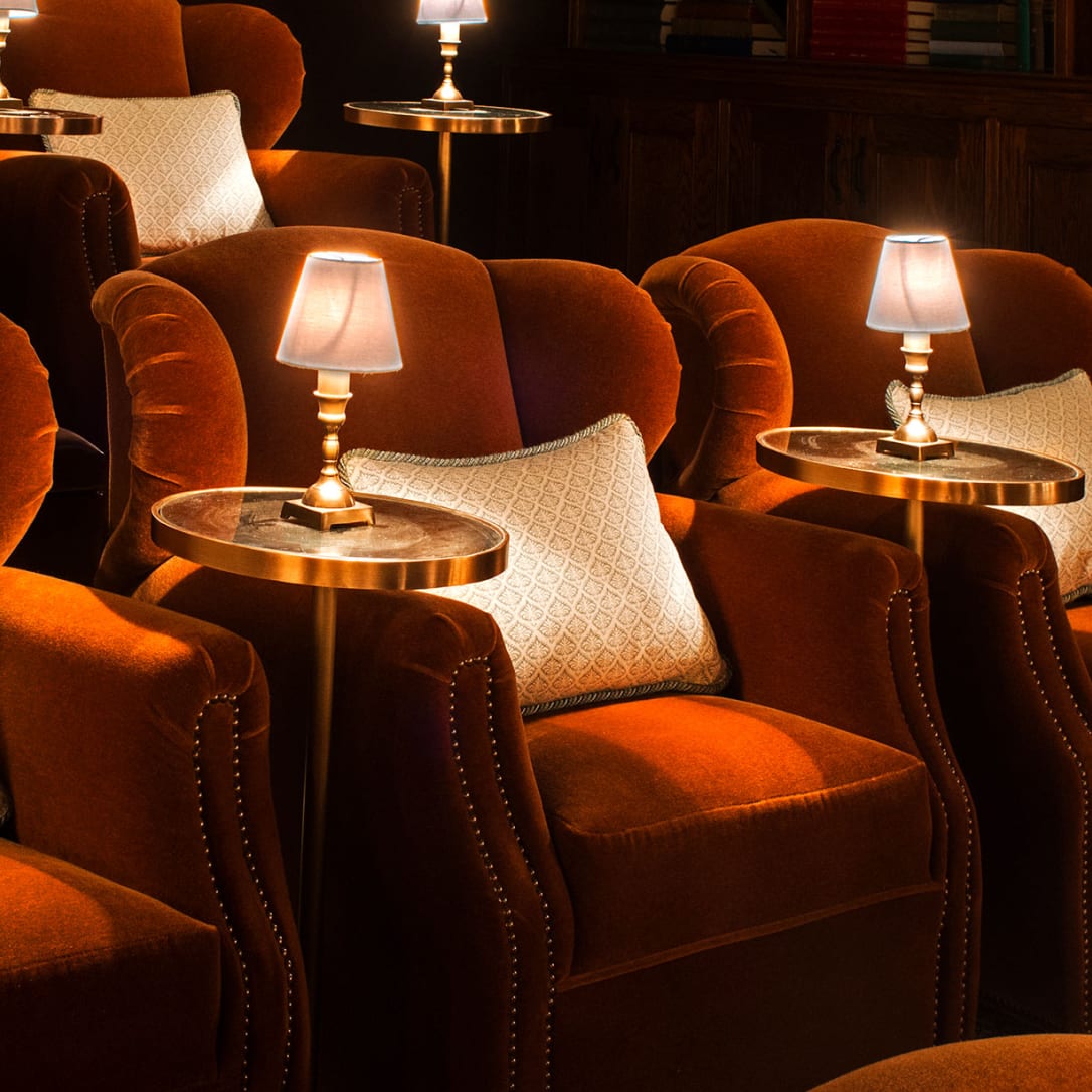 Large red armchairs in rows with side tables and lamps.