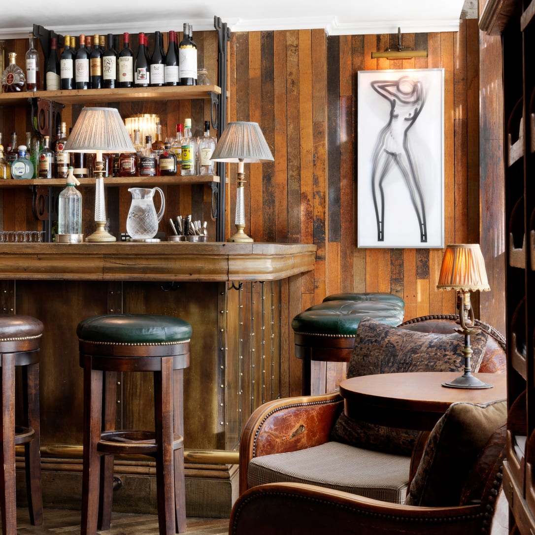 A bar with high stools and artwork on the walls.