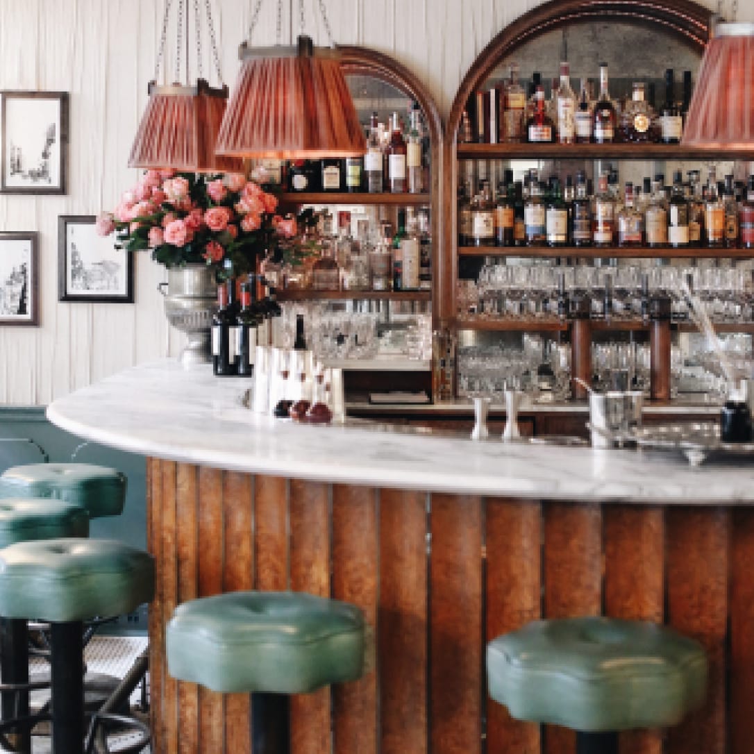 A semi circular marble bar with high chairs.