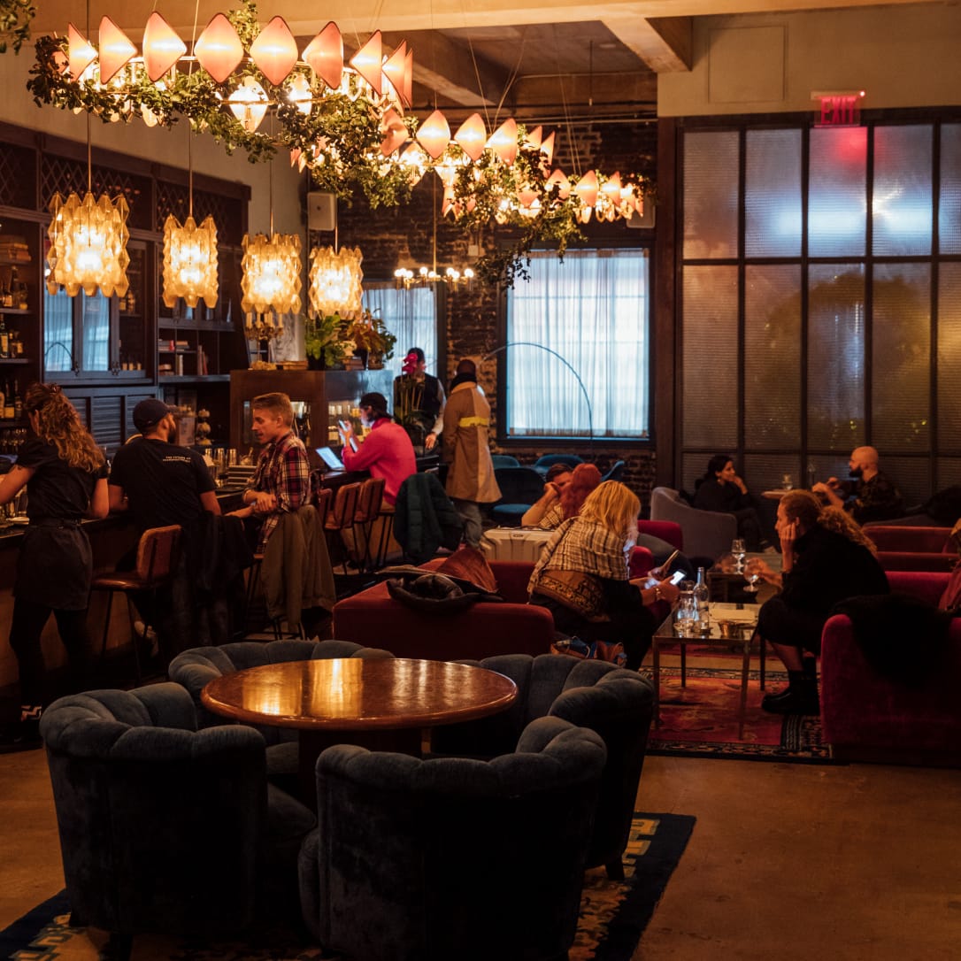 People sat in a relaxed, warmly lit bar interior.