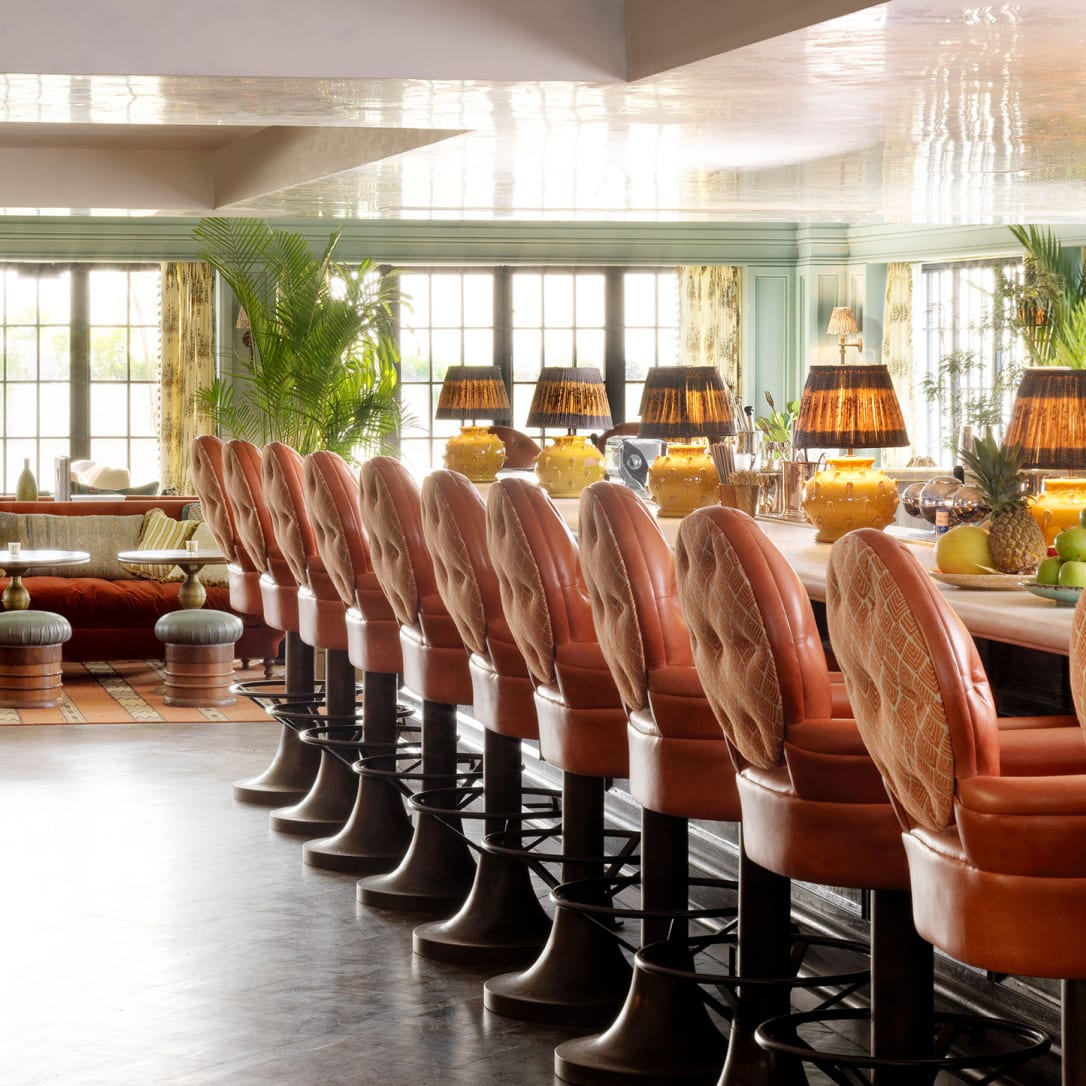 A long wooden bar with many high chairs.