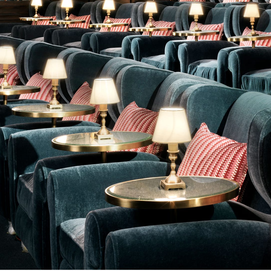 Rows of blue armchairs with side tables and lamps.