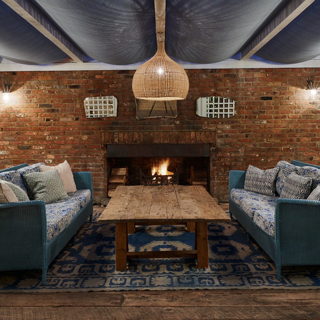 Two sofas and a coffee table by a burning fire.