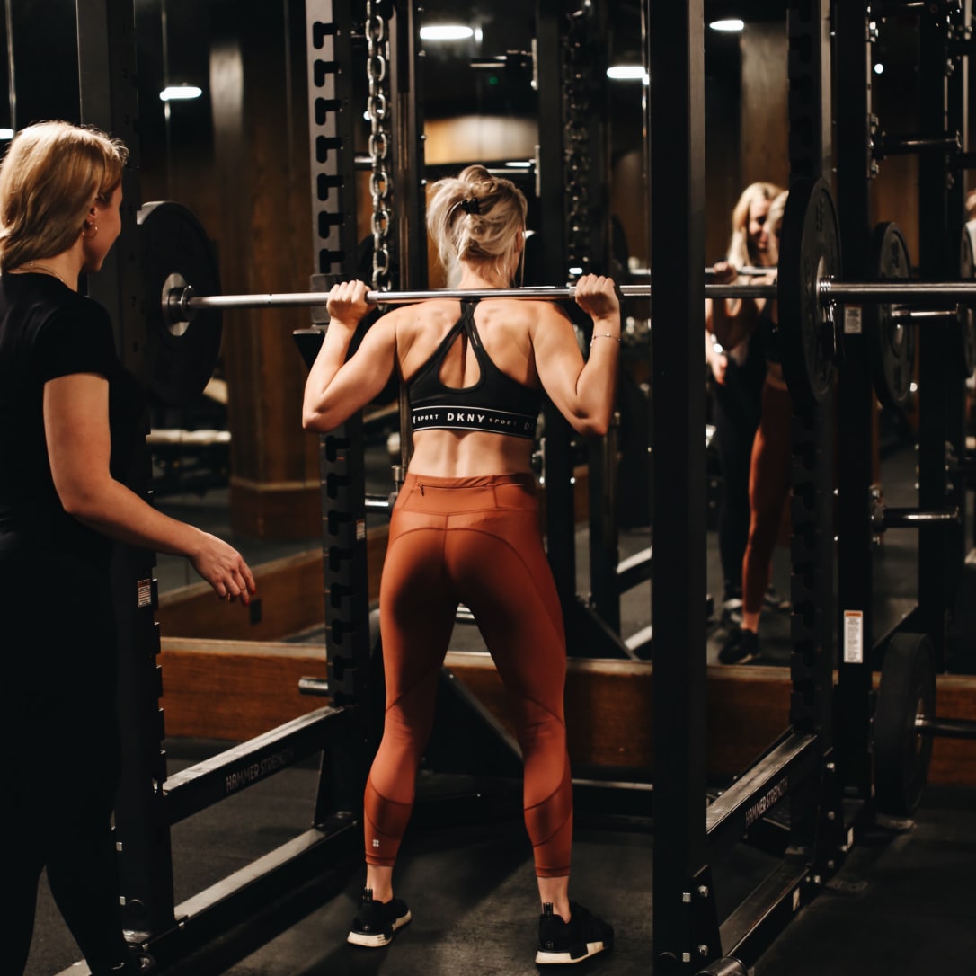 Two women working out using weights.