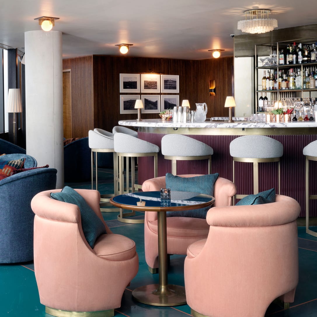 Many tables and chairs in a large bar area.