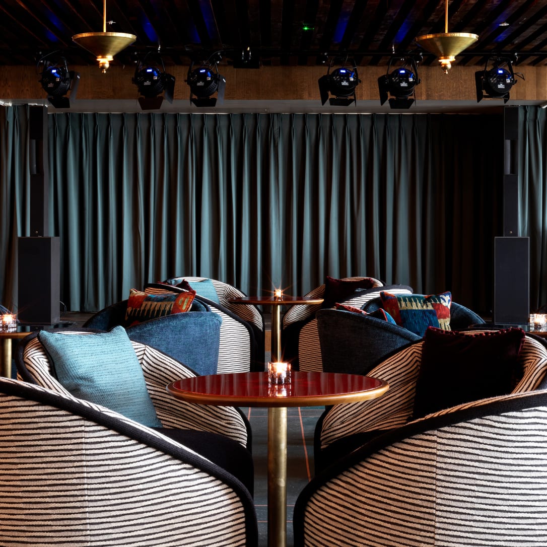 Tables and chairs in front of a stage.