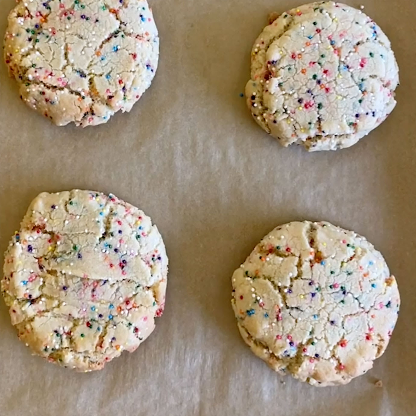 Four cookies with colourful sprinkles in them.