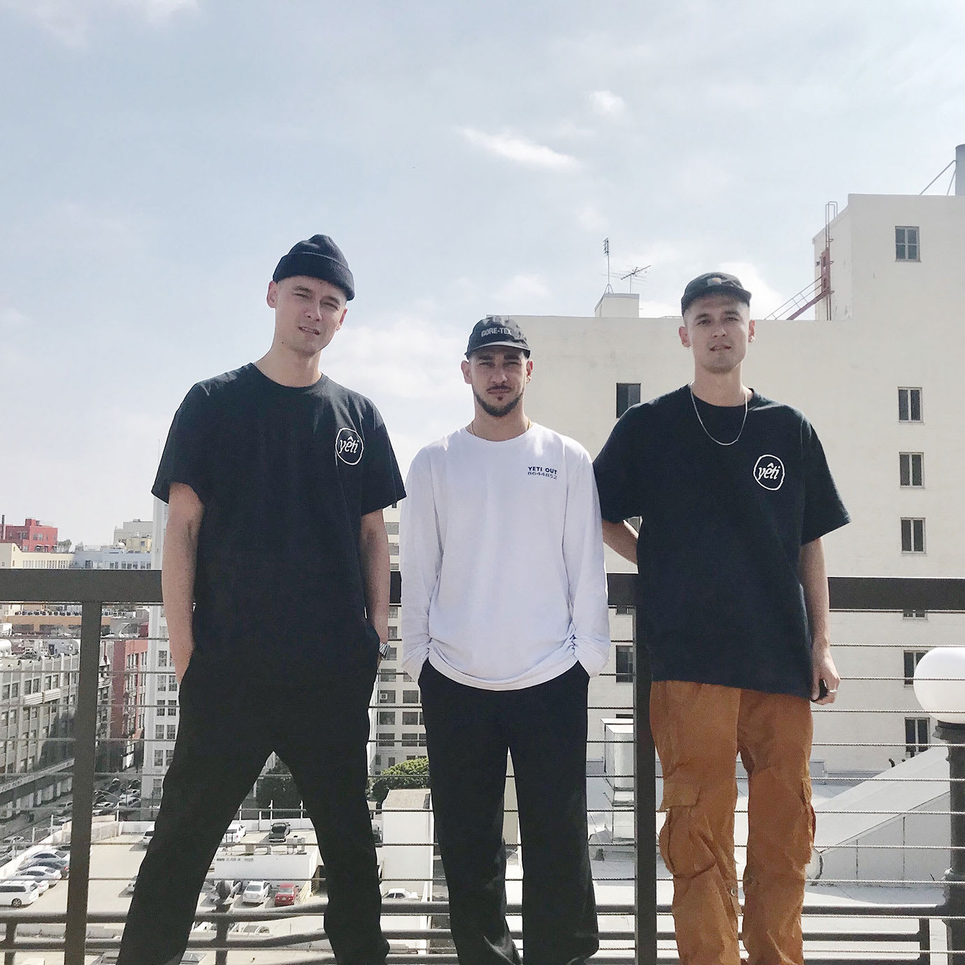 Three men standing on a roof in a city.