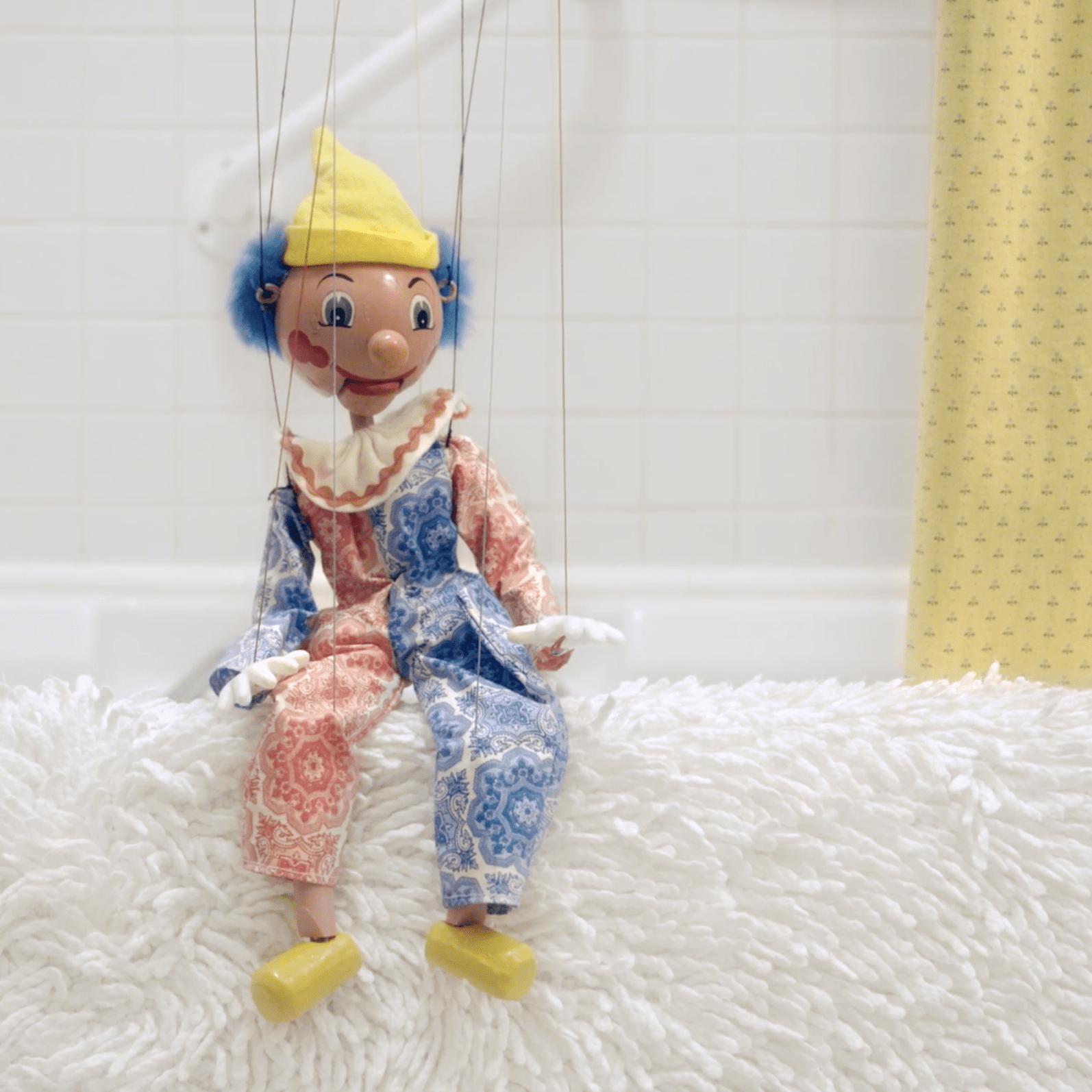 a puppet on edge of bathtub.