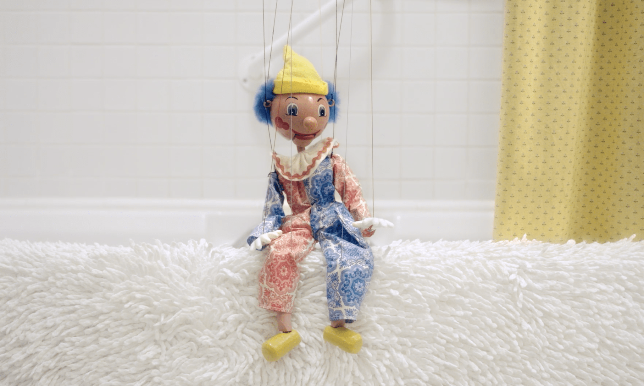 a puppet on edge of bathtub.