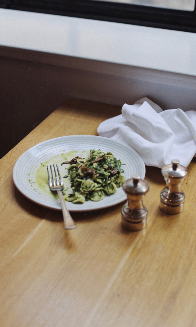 A half eaten plate of pasta on a table.