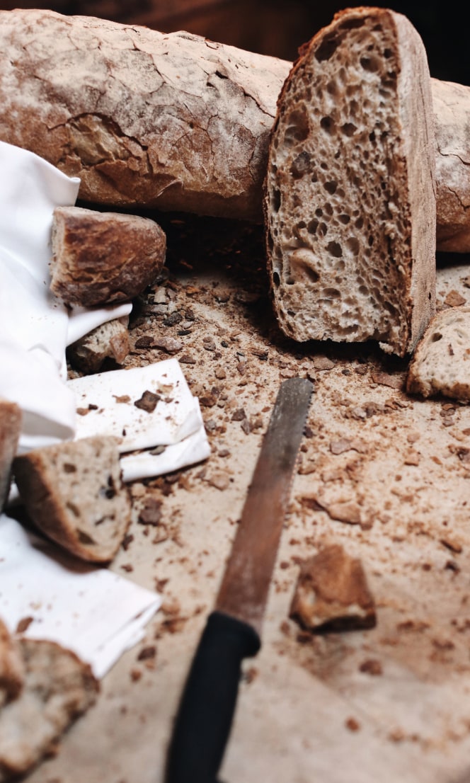 Sliced bread and crumbs on a wooden board.