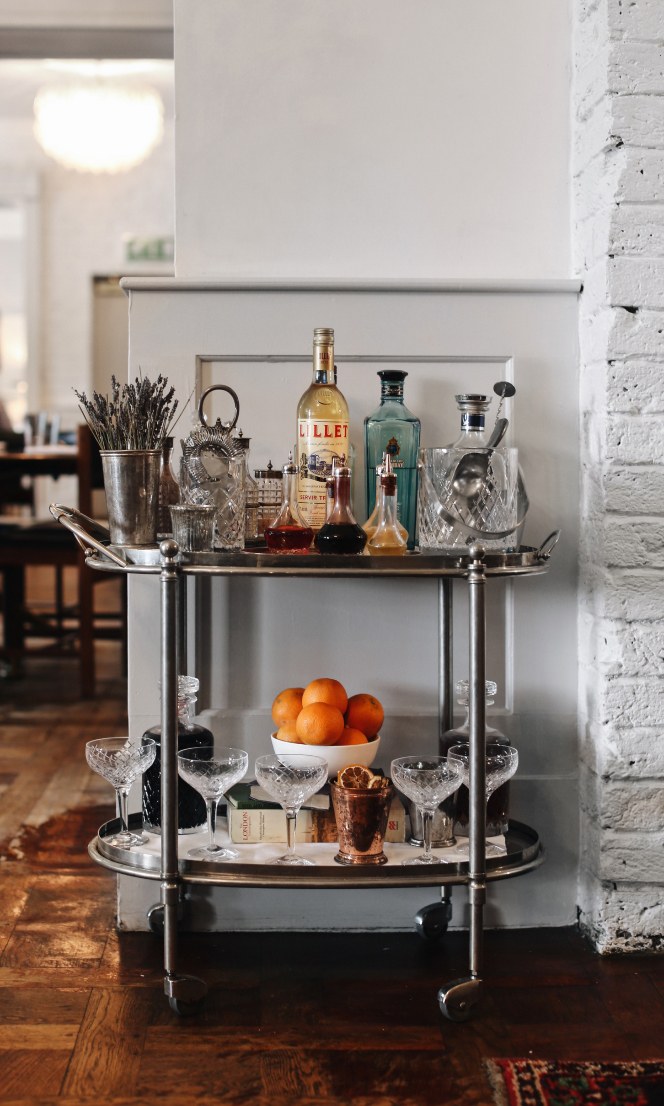 A drinks trolley containing bottles of alcohol and other cocktail ingredients.