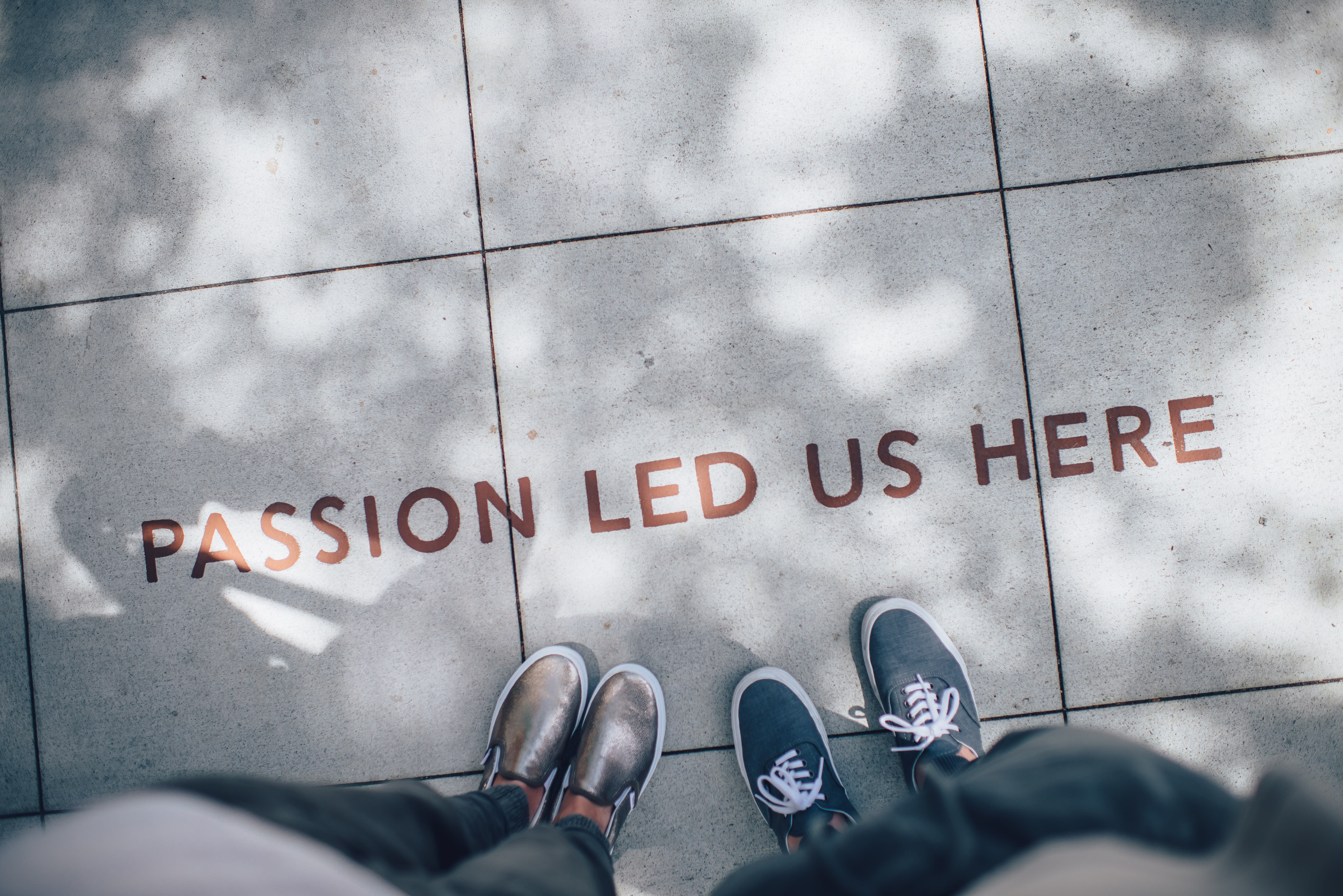 People standing at quote written on the floor. Quote: "Passion led us here."