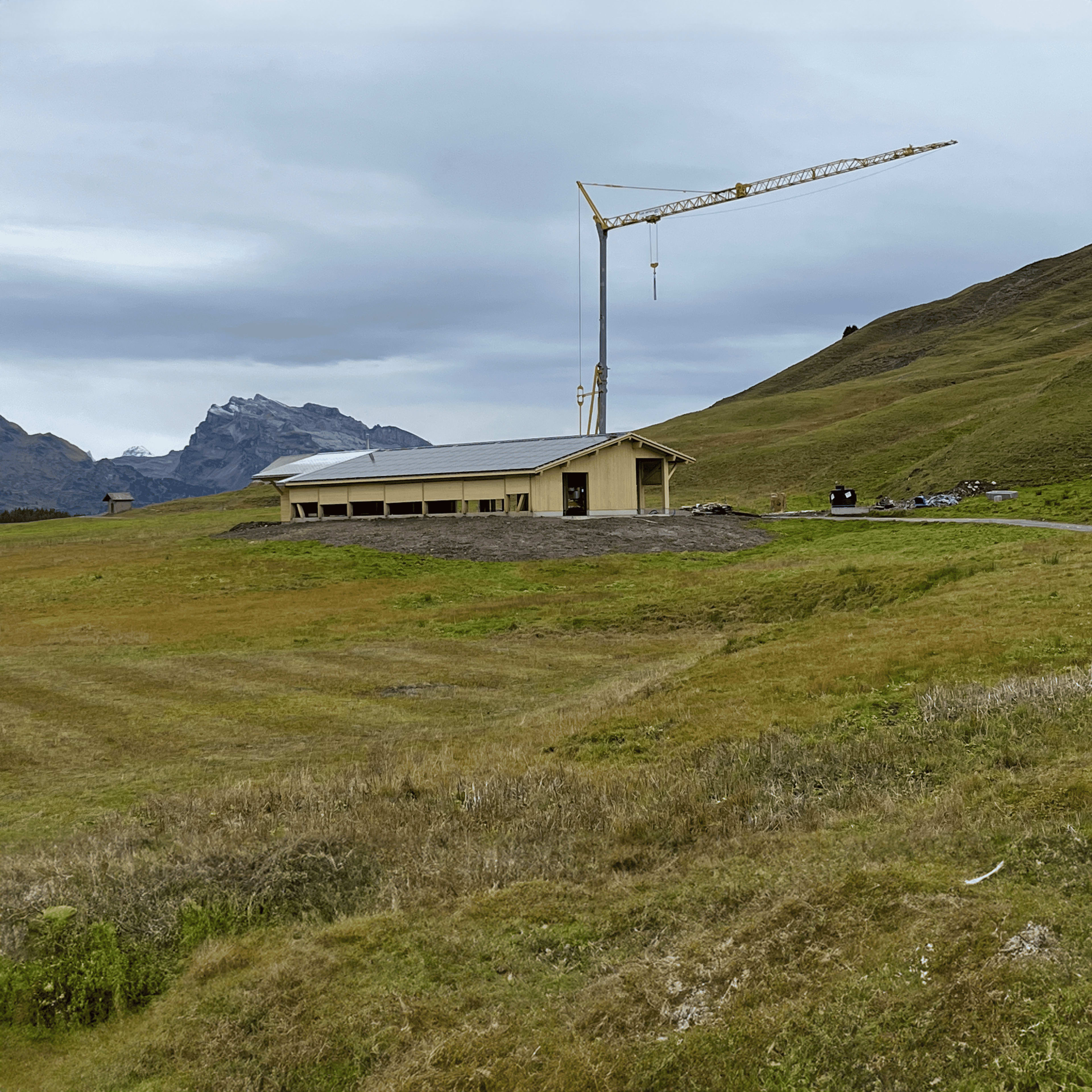 Gebäude in ländlicher Berglandschaft im Bau mit Kran, Solaranlage auf dem Dach, installiert von SolarKiosk.
