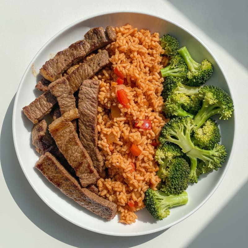 Seared Beef Strips with Jollof Rice and Steamed Broccoli