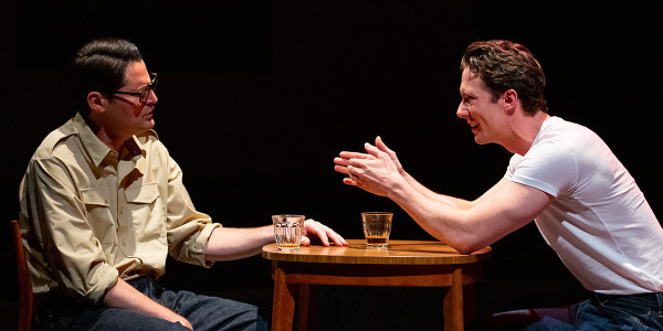 Two men chatting whilst sat at a table